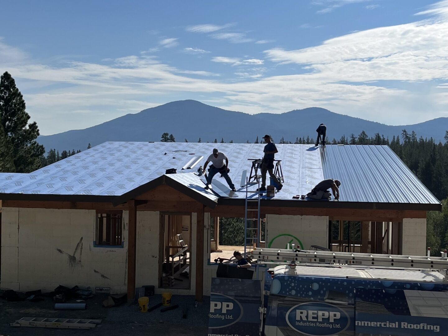 Professional contractors installing durable commercial flat roofing on a warehouse.